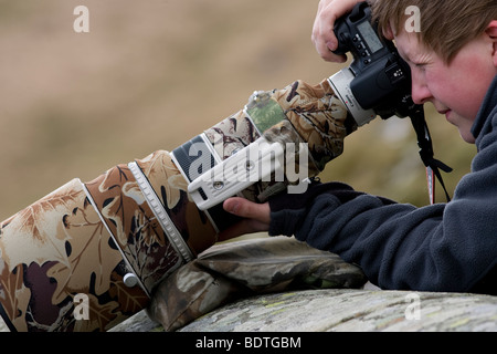 Photographe professionnel Lee Webb en utilisant un Canon 400mm f/2,8 super téléobjectif pour photographier Red Kites en vol par Elan Valley, le Pays de Galles. Banque D'Images