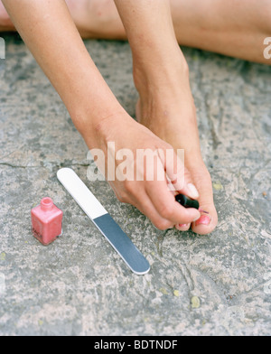 Femme à l'aide de vernis à ongles Banque D'Images