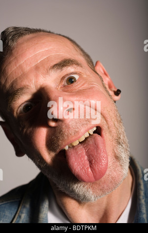 Homme avec punk rocker regarder coller sa langue dehors. Banque D'Images