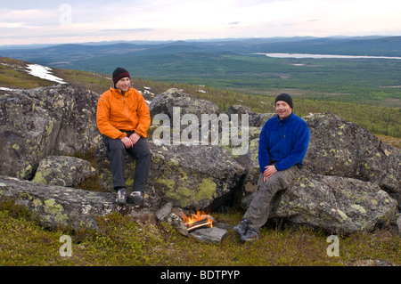 Les hommes sont sur le gril à un bon feu de fjell, Laponie suédoise Banque D'Images