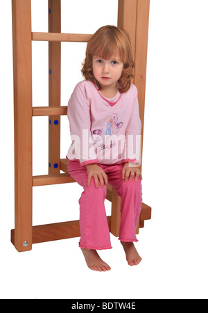 Petite fille en pyjama assis sur le Billi-Bolli ledder d'un lit en mezzanine Banque D'Images