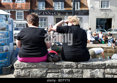 Deux femmes siègent au mur dans le soleil. Banque D'Images