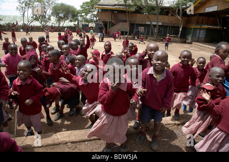 KENYA Enfants en uniforme jouant en cour du Christ Roi de l'école catholique, Kibera, un bidonville de Nairobi. Banque D'Images