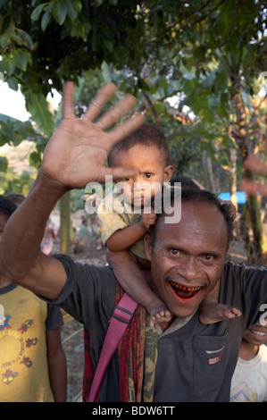 L'HOMME AU TIMOR LESTE (avec vitraux de bétel bouche) exerçant son enfant et en agitant, photographie par Oecussi-Ambeno SEAN SPRAGUE 2007 Banque D'Images
