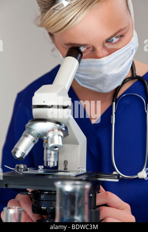 Une belle femme médecin ou chercheur scientifique à l'aide de son microscope dans un laboratoire. Banque D'Images