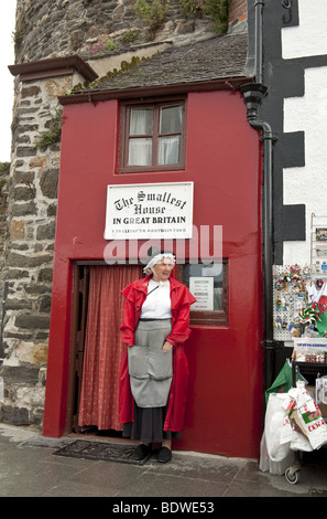 Femme en costume traditionnel gallois en face de plus petite maison en Bretagne sur quai du nord du Pays de Galles ville de Conwy Banque D'Images