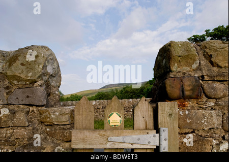 Une porte dans un mur dans le Yorkshire Dales, montrant un sentier public marqueur. Banque D'Images