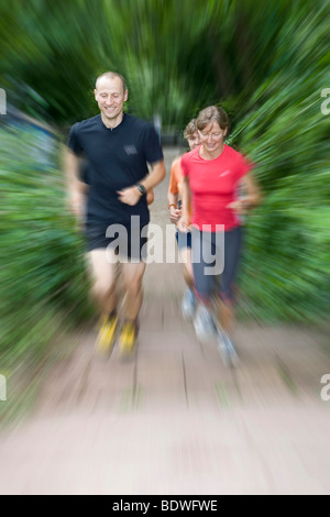 L'homme et trois femmes jogging dans la forêt Banque D'Images