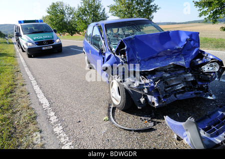 L'épave d'un VW Polo après un grave accident de voiture, une voiture de police derrière pour sécuriser le site de l'accident, Gaertringen, Baden-Wuerttember Banque D'Images