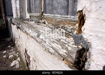 D'écaillage de la peinture blanche d'un ancien, mal entretenu, châssis de fenêtres en bois. Banque D'Images