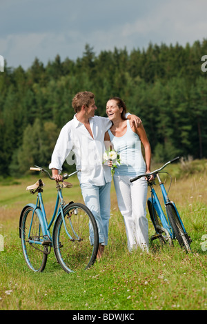 Couple romantique avec vieux vélo dans le pré aux beaux jours Banque D'Images