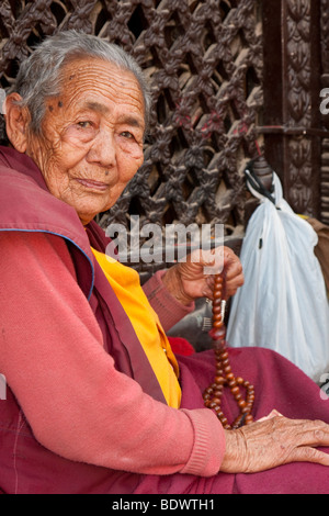 Bodhnath, au Népal. Vieux homme népalais, un moine bouddhiste, avec la prière des perles. Banque D'Images