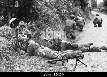 D-Day soldat américain tente de débusquer l'ennemi par attirer le feu le long de la hedgrows mortelle près de Carentan, France, en juin 1944 Banque D'Images