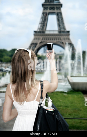 Jeune femme photographier la Tour Eiffel, Paris, France, Europe Banque D'Images