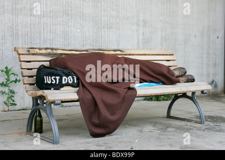 Un homme sans abri dans le quartier du gouvernement de Berlin sur un banc de parc, Berlin, Allemagne, Europe Banque D'Images