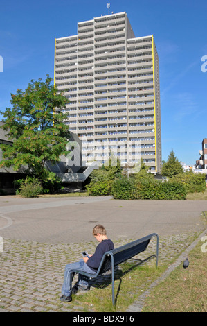 Garçon, 9, jouant avec sa Nintendo en face d'une tour d'habitation, ville satellite de Chorweiler à Cologne, au nord Rh Banque D'Images