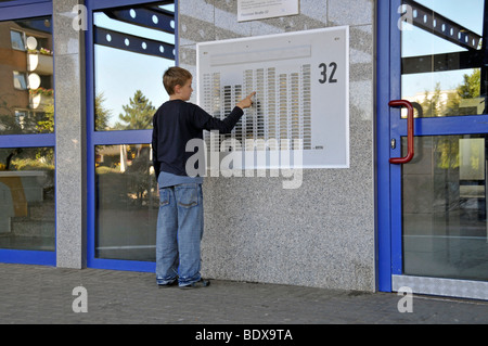 Garçon, 9, debout devant la porte avant d'un tour d'habitation, ville satellite de Chorweiler, ni à Cologne Banque D'Images