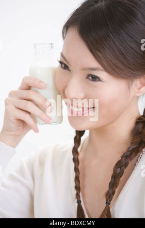 Jeune femme tenant une bouteille de lait, portrait Banque D'Images
