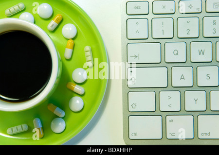 Des dessus et des médicaments psychotropes à côté d'un clavier d'ordinateur, image symbolique pour le dopage au travail Banque D'Images