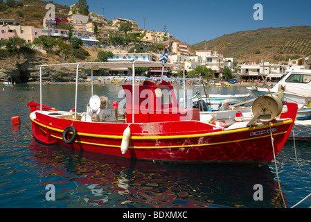 Rouge et jaune peint de couleurs vives, bateau de pêche grec ligoté en Crète Harbour Banque D'Images