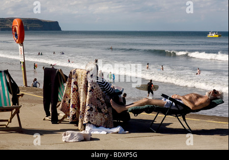 Couple par un front de mer animé, Whitby, North Yorkshire, Angleterre Banque D'Images