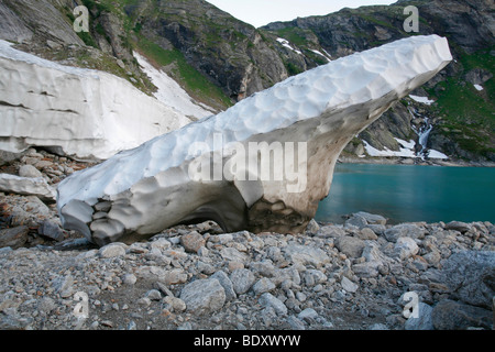 Plateau de neige ancienne tôt le matin sur la rive de la Lago del Zoett Basòdino, réservoir, région de Robiei, Tessin, Suisse Banque D'Images