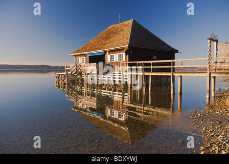 Un garage à bateaux et son reflet dans le lac Ammersee, à Buch, Bavaria, Germany, Europe Banque D'Images