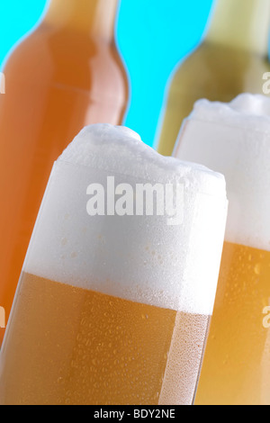 Verres de bière plein devant des bouteilles de bière Banque D'Images