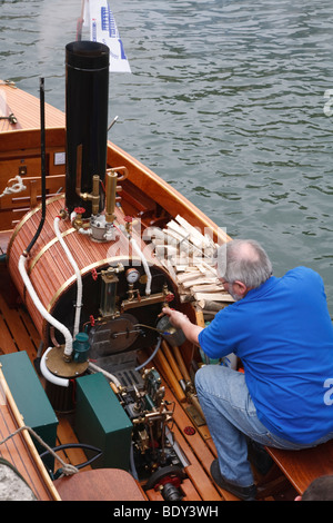 Un passionné vérifie le moteur d'un bateau à vapeur traditionnel Banque D'Images