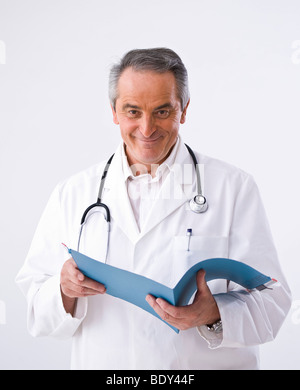 Médecin avec un stéthoscope tenant dans ses mains des dossiers patient Banque D'Images