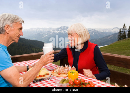 Senior couple eating in mountains Banque D'Images