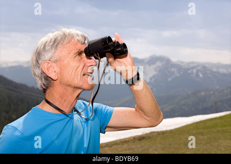 Man avec des jumelles dans les montagnes Banque D'Images