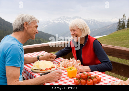 Senior couple eating in mountains Banque D'Images