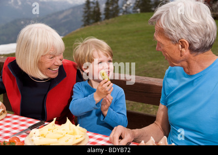 Couple et petit-fils de manger dans les montagnes Banque D'Images