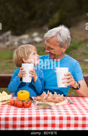 Grand-père, petit-fils de manger en montagne Banque D'Images