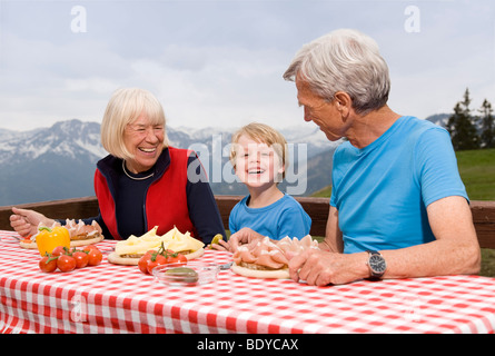 Couple et petit-fils de manger dans les montagnes Banque D'Images