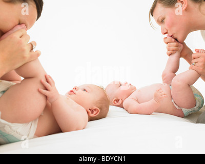 Jouant avec des bébés de mères Banque D'Images