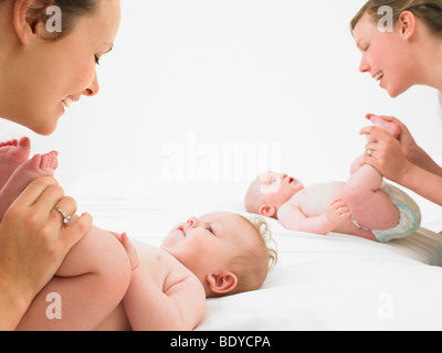 Jouant avec des bébés de mères Banque D'Images