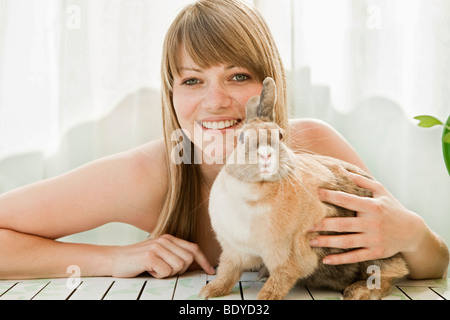 Jeune femme et d'un animal de compagnie lapin sur un patio Banque D'Images