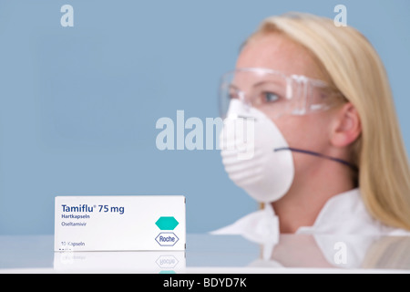 Pharmacien avec masque de protection et le médicament Tamiflu Banque D'Images