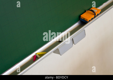 Un conseil d'orange et gomme la craie sur un tableau noir. Banque D'Images