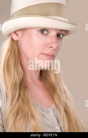 Young blonde woman with hat semble intéressé Banque D'Images