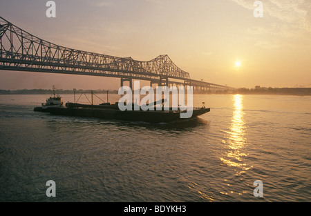 Un bateau remorqueur pousser avec une barge et un pont sur le fleuve Mississippi à la Nouvelle Orléans, Louisiane Banque D'Images