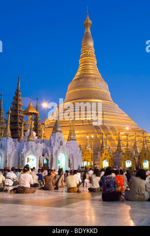 Birmans priant devant le stupa doré, la pagode Shwedagon, la nuit, Rangoon, Yangon, Birmanie, Birmanie, Myanmar, en Asie Banque D'Images