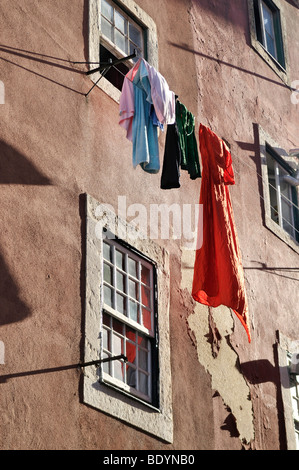 La pendaison de blanchisserie sèche sur une ligne en face d'une maison avec des murs en plâtre en ruine dans le quartier d'Alfama, Lisbonne, Portugal, Banque D'Images