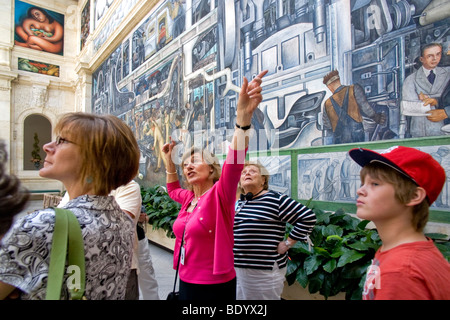 A Detroit Institute of Art docent explique le célèbre musée Diego Rivera peintures murales de l'usine Ford de Rouge à un groupe de touristes. Banque D'Images