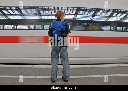 Garçon, 9, sur la plate-forme à l'avant d'un train ICE de passage, principale gare ferroviaire de Cologne, Rhénanie du Nord-Westphalie, Germ Banque D'Images