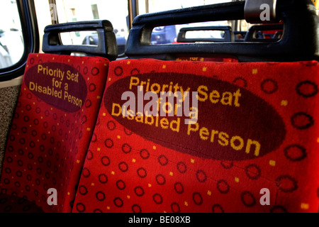 Rouge lumineux sièges prioritaires pour les personnes handicapées sur un bus à Brighton, East Sussex, UK. Banque D'Images