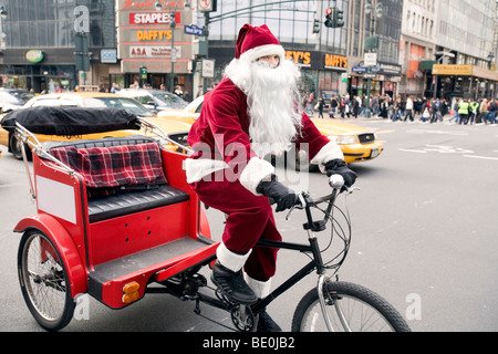 Santa monte un vélo taxi à New York. Banque D'Images
