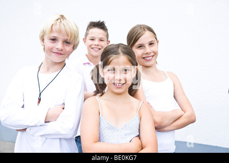 Quatre amis, bras croisés, cool, dans la cour de l'école Banque D'Images